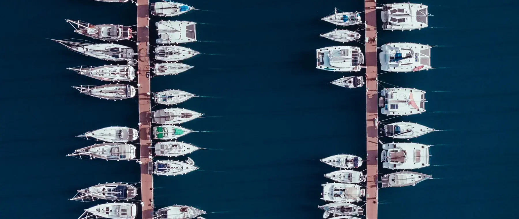 Rows of boats docked at a marina from above