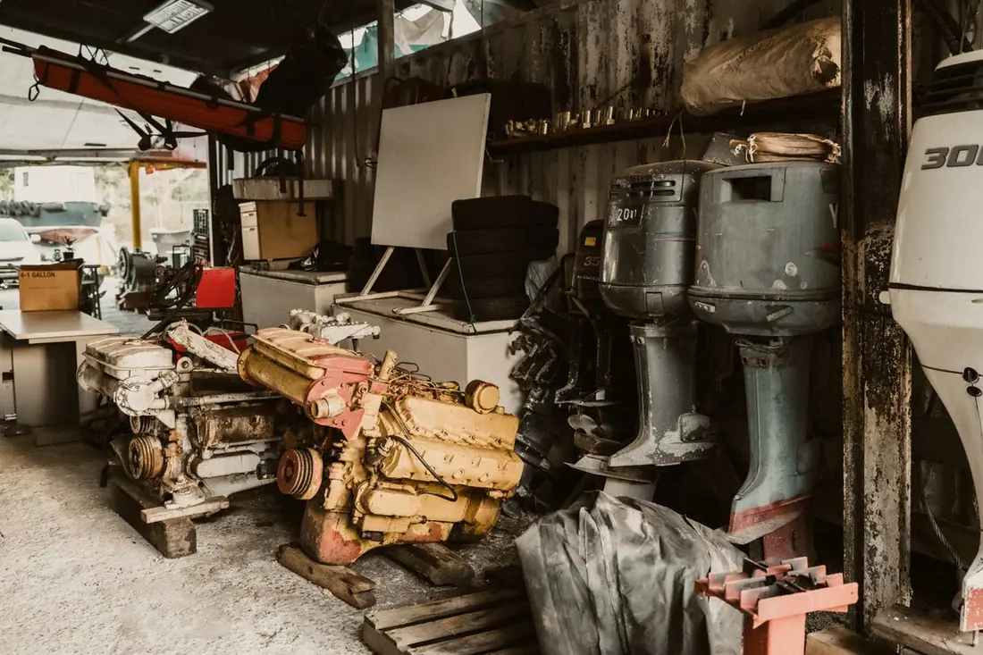 Old outboard powerheads stacked in a workshop